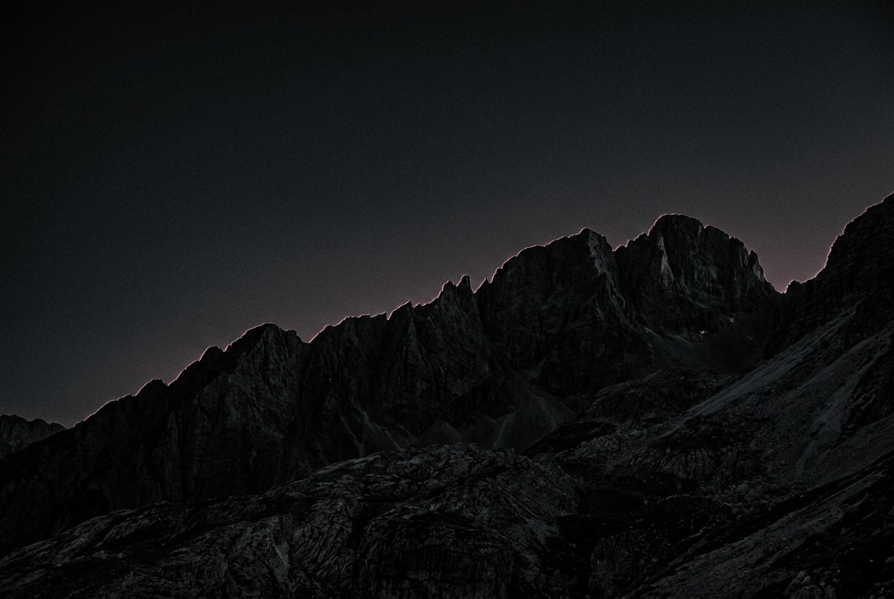 A dark mountain ridge with a faint rose rim light — the quiet, local boundary ZANCTA keeps around your files